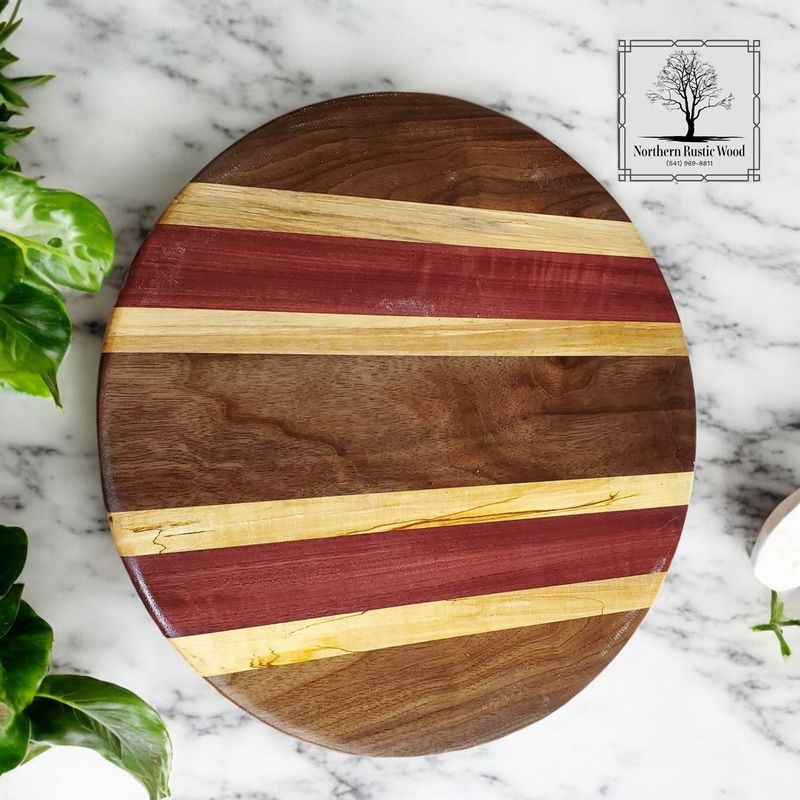 handmade round cutting board made with purpleheart, black walnut and maple hardwood. By Northern Rustic Wood