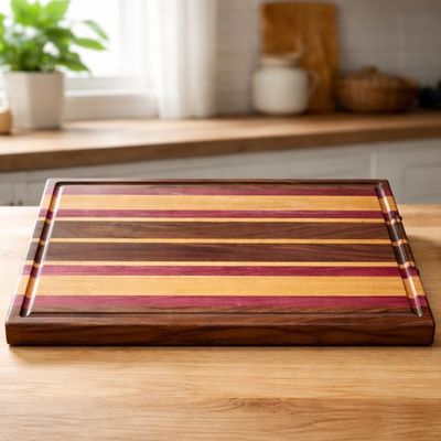 This handcrafted cutting board features a bold combination of Black Walnut, Purpleheart, and Maple hardwoods.