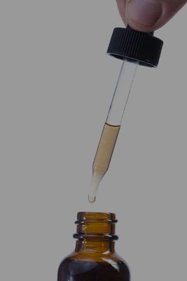 Functional mushroom tincture dropper dispensing dual-extracted liquid into amber glass bottle — Steel Ridge Farm