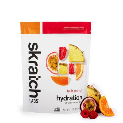 Skratch Labs Sport Hydration Drink Mix 440g pouch shown beside fruit; formulated to replenish electrolytes lost in sweat.