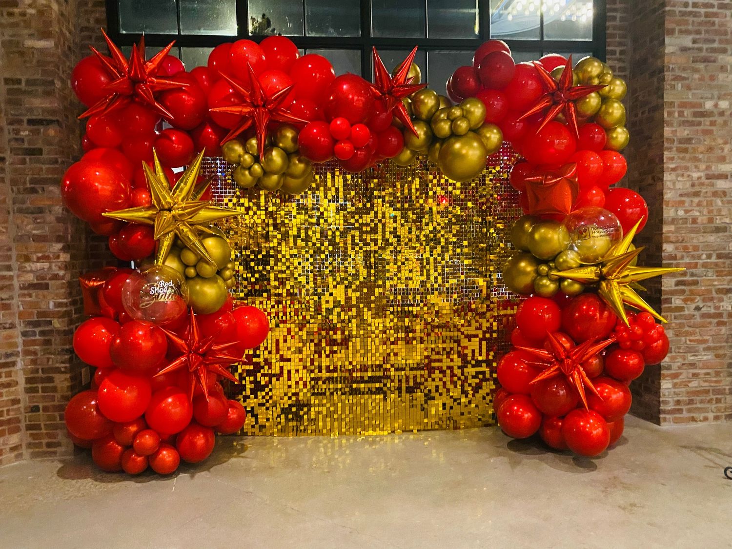 Gold Shimmer Wall w/ Gold and Red Organic Balloon Arch