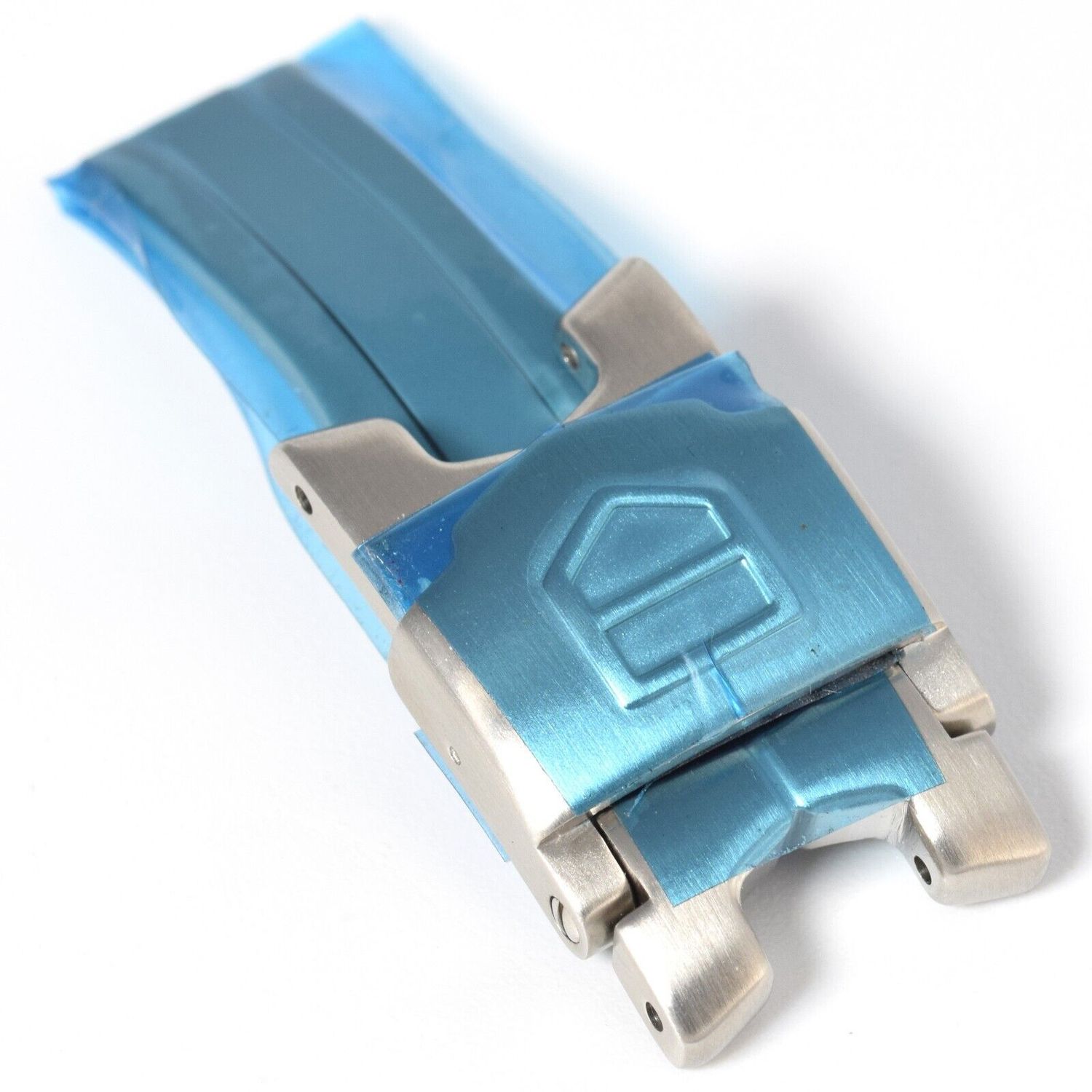 New TAG Heuer 16mm steel clasp buckle with protective blue film showing the TAG Heuer logo embossed on the clasp