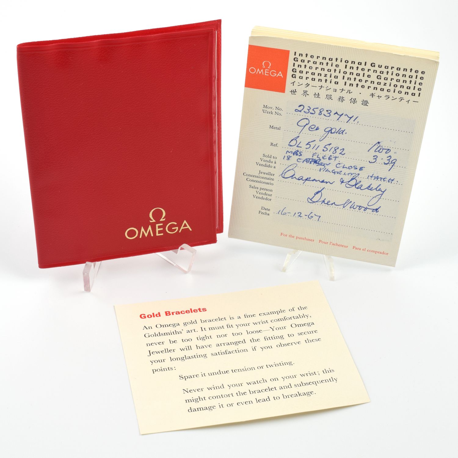 Omega International Guarantee booklet set including a red wallet with gold Omega logo, a filled-out guarantee card showing handwritten details like &quot;23583747/1&quot;, &quot;18ct gold&quot;, &quot;06.511.5182&quot;, &quot;3.3g&quot;, and dated &quot;16.12.67&quot;, along with a cream card titled &quot;Gold Bracelets&quot; providing care instructions for gold bracelets