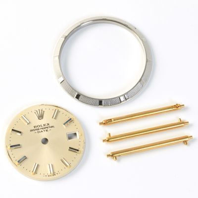 Rolex grooved bezel, Rolex golden watch dial, three gold Cartier quick release sprig bars