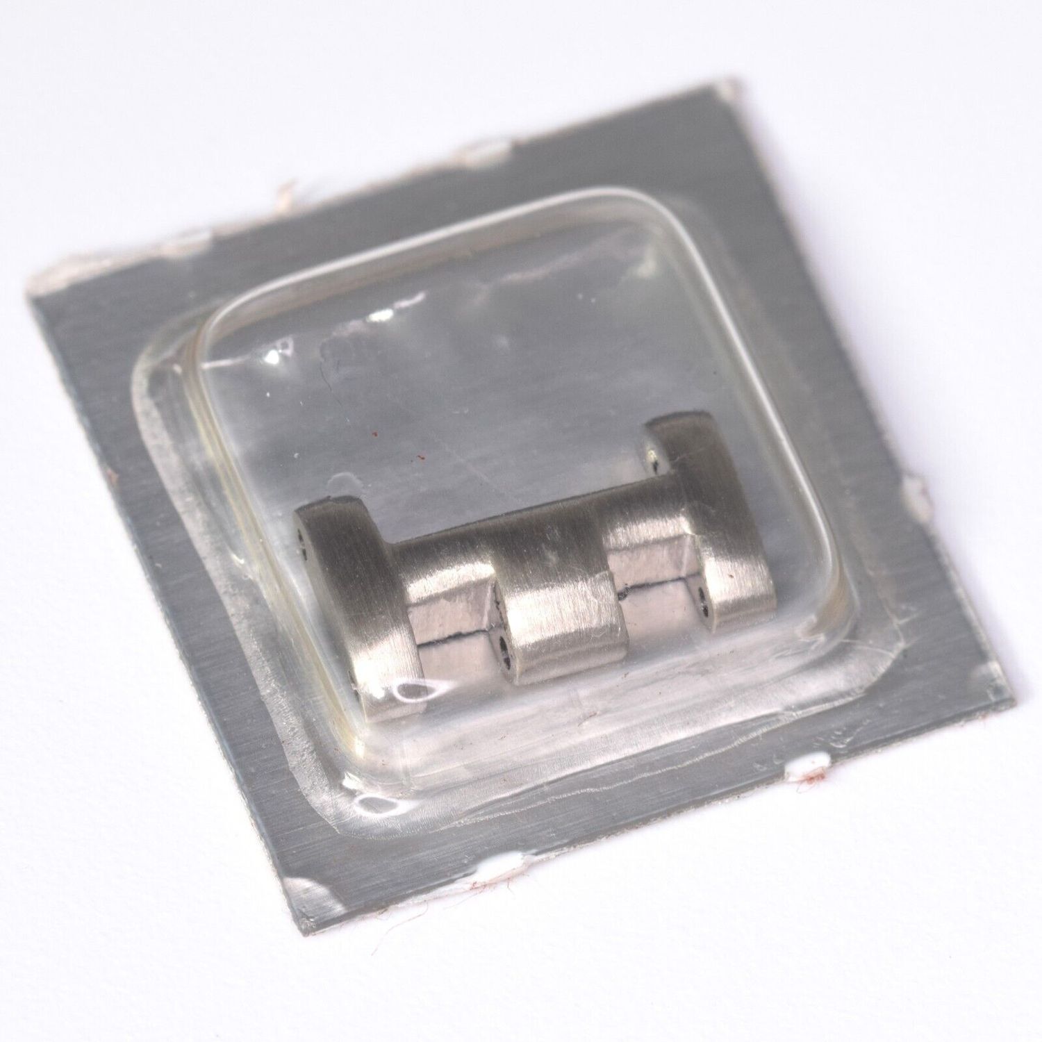 Genuine Omega Seamaster ladies 13mm wide clasp end link part number 118ST6502 shown sealed in original blister packaging with three brushed steel link sections connected and aligned in a row
