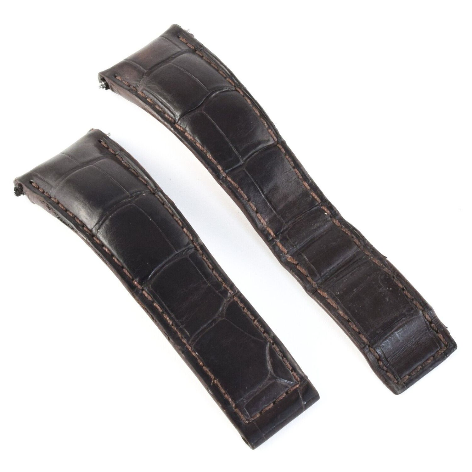 Dark brown alligator leather TAG Heuer watch strap showing curved padding and visible edge wear with fine stitching around the edges