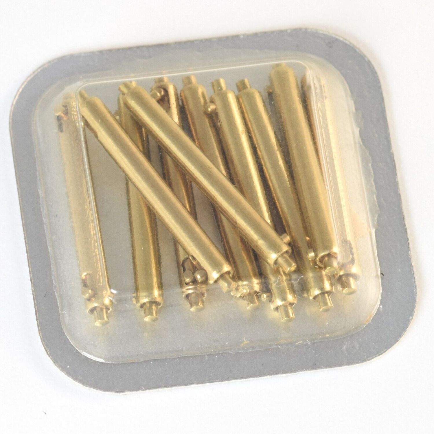 sealed blister pack containing 10 gold-plated quick release Cartier spring bars for Panthère medium watch arranged randomly under clear plastic