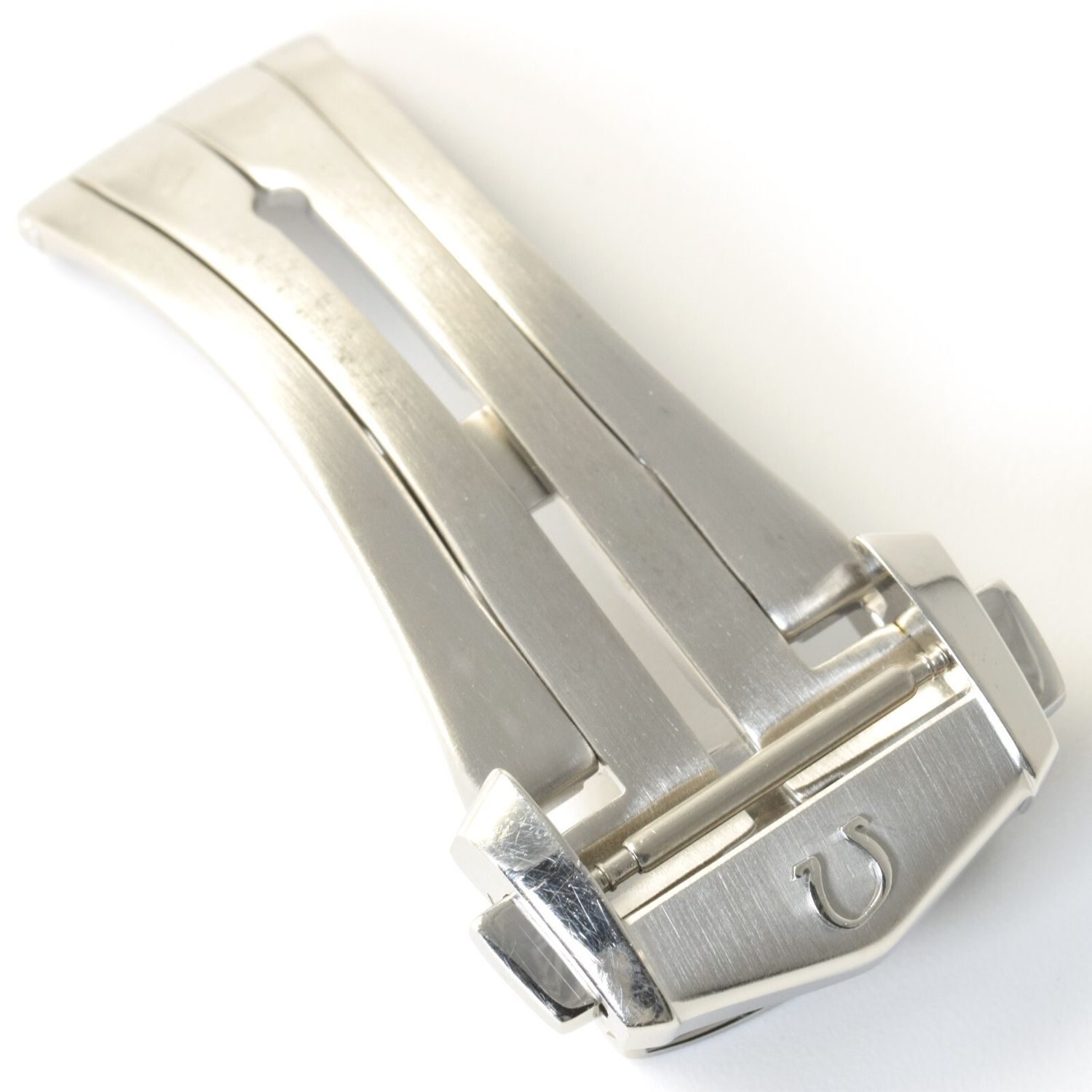Authentic Omega STZ007387 stainless steel deployment watch clasp with brushed finish, showing bent Omega logo and visible surface scratches