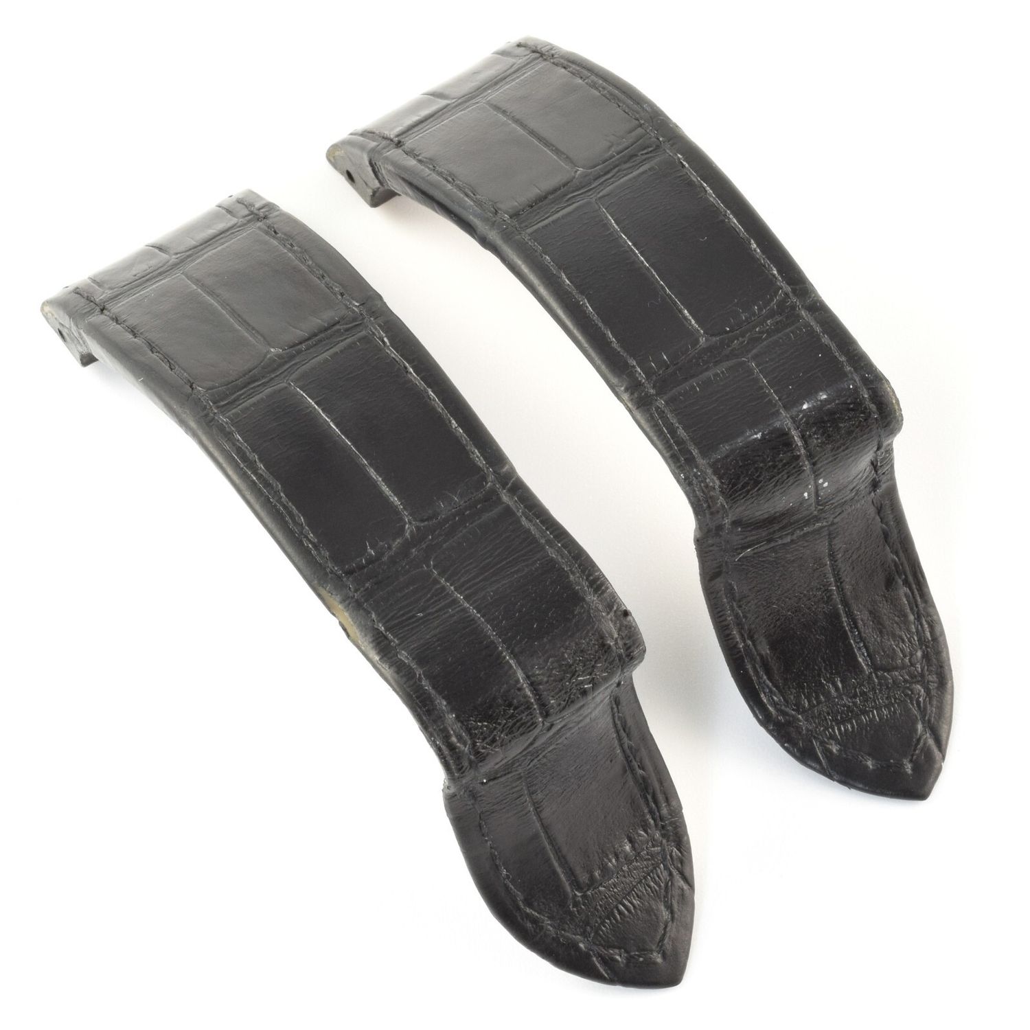 Authentic Cartier Santos 100 XL black alligator leather watch strap showing two curved pieces with visible scale pattern and slight signs of use