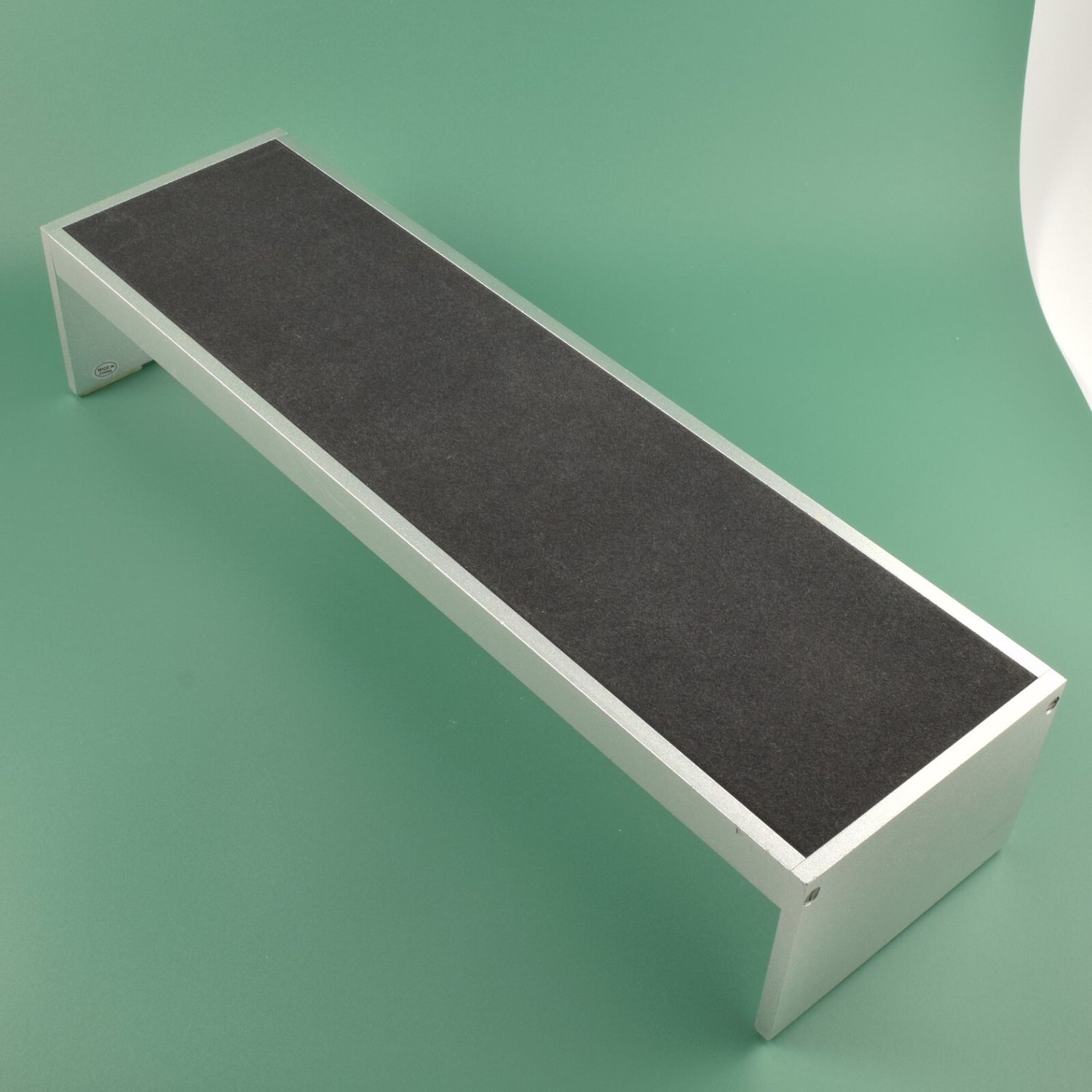 Authentic Breitling dealer long watch display stand made from wood with silver sides and a black felt top surface without branding