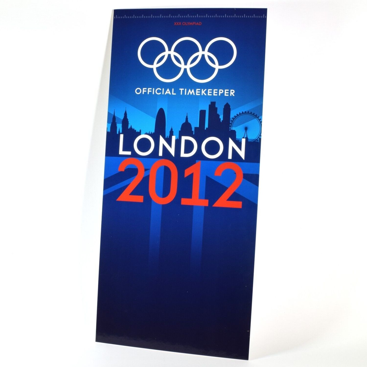 New Omega London 2012 Olympics advertising board showing the Olympic rings, “Official Timekeeper” text, a London skyline silhouette, and bold red “2012” text over a blue background with Union Jack accents