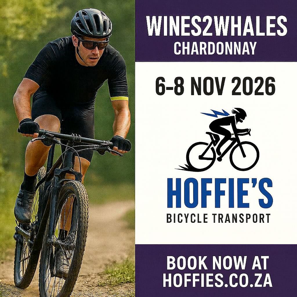 Mountain biker racing on a forest trail alongside a Hoffie’s Bicycle Transport poster for Wines2Whales Chardonnay 6–8 Nov2026