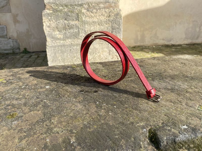 Ceinture rouge façon autruche. Largeur 2 cm, boucle à rouleau.