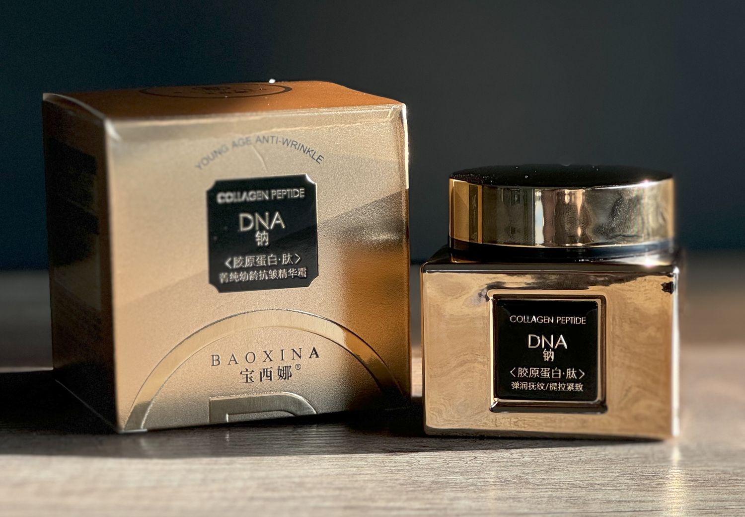 Złoty słoiczek kremu z kolagenem i DNA o działaniu anti-wrinkle stojący na drewnianym stole, produkt Baoxina