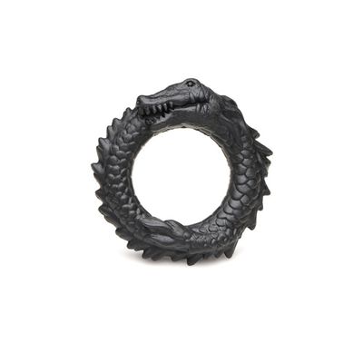 A black silicone c-ring shaped like a black caiman curling in on itself, textured with prominent scales and ridges.