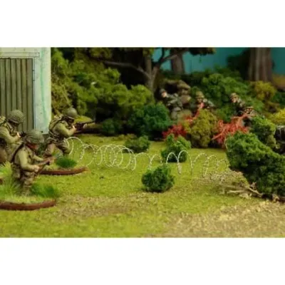 Bolt Action: Barbed Wire 3m Bolt Action barbed wire terrain shown across a tabletop battlefield with soldiers and greenery.