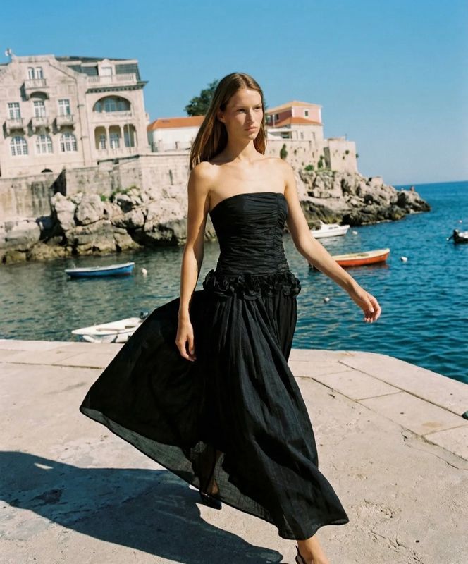 Strapless zwarte maxi jurk met elegante pasvorm. Perfect voor gala, trouwfeest of chique avond.