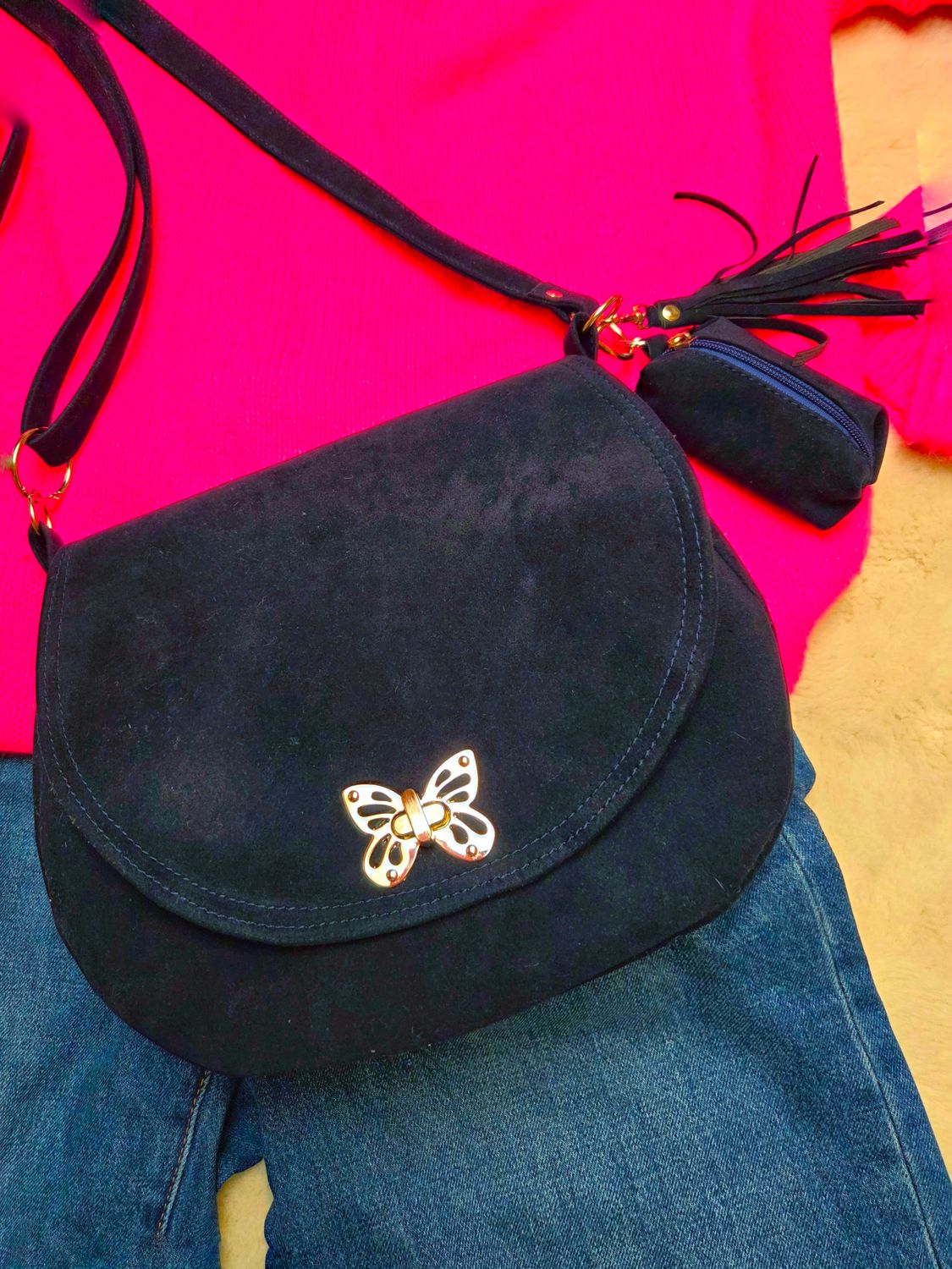 Półokrągła granatowa listonoszka z klapką.