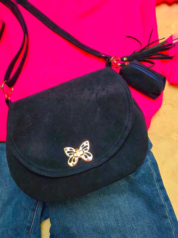 Półokrągła granatowa listonoszka z klapką.