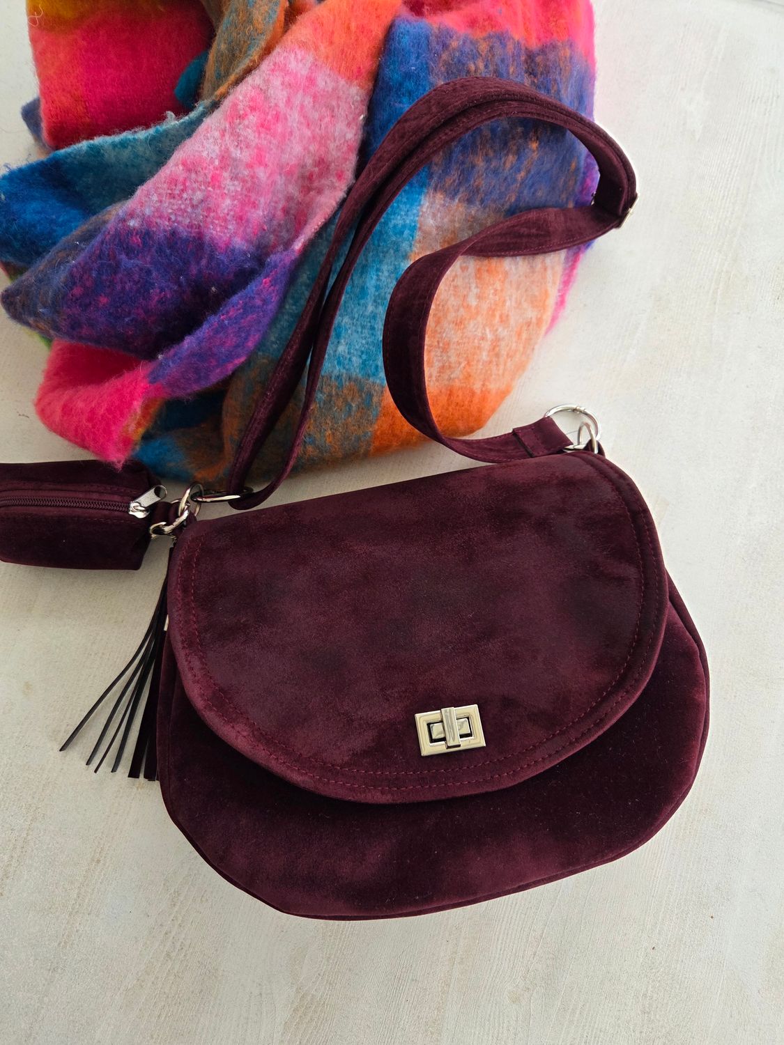 Półokrągła burgundowa listonoszka z klapką.