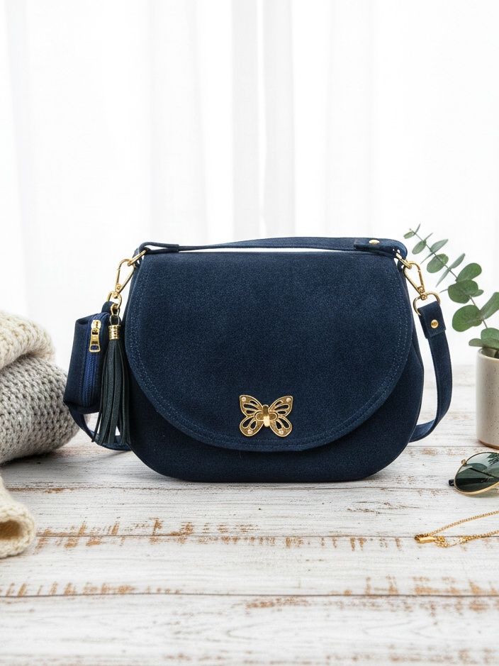 Półokrągła granatowa listonoszka z klapką.