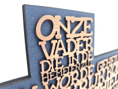 Kruis met de tekst van Christelijke gebed &quot;Het Onze Vader&quot; uitgesneden in houten letters.