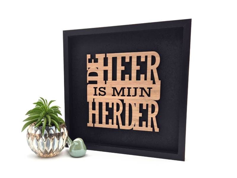 Zwart schilderij met laser gesneden Christelijke tekst uit Psalm 23, De Heer is mijn Herder. Het hout is bruin bamboehout.