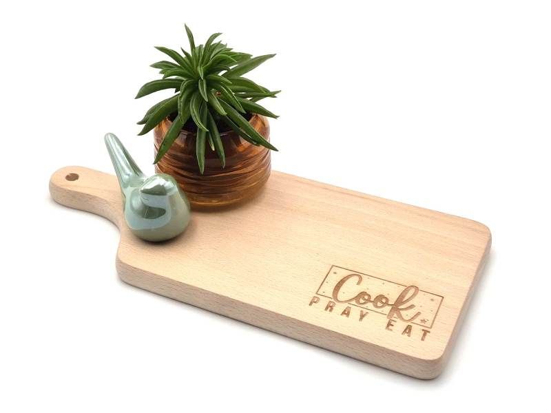 Foto van beukenhouten plank met gepersonaliseerde tekst &quot;cook, pray, eat&quot;.