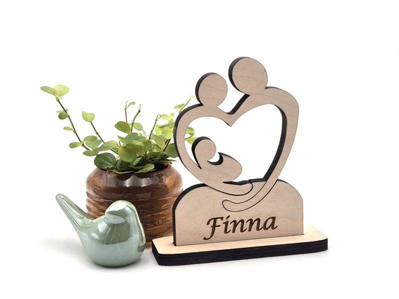 Houten item van twee ouders die een kind omarmend. Het geboorte cadeau is gepersonaliseerd met de naam van het kind.