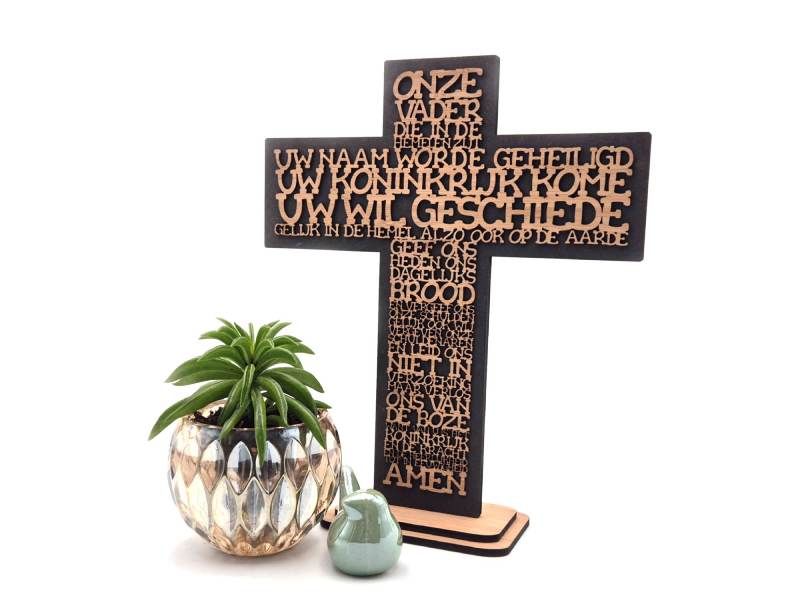 Kruis met zwarte achtergrond, gevormd door de letters van het Christelijke gebed uit Mattheus &quot;Het Onze Vader&quot;.