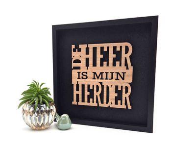 Zwart decoratief schilderij met de in hout uitgesneden Christelijke tekst &quot;De Heer is mijn herder&quot; uit Psalm 23.