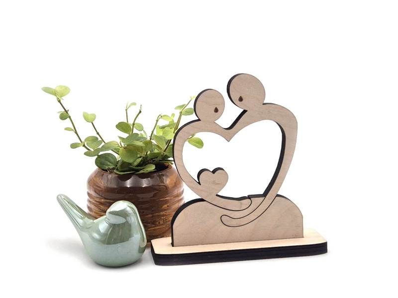 Betekenisvol cadeau van twee ouders die een hart omarmen als symbool van het herinneren van een verloren ongeboren kind.