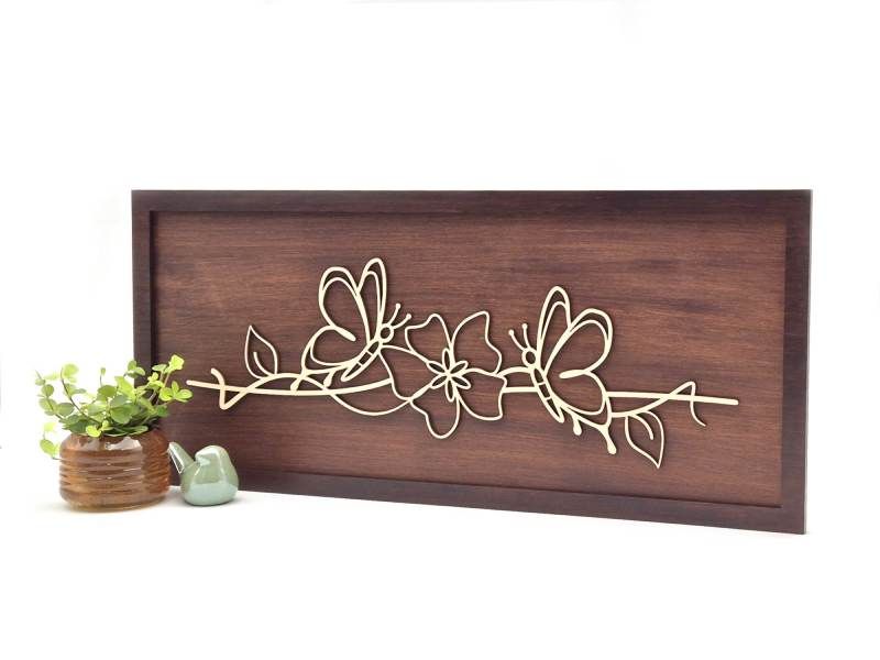 Rechthoekig houten decoratief schilderij met lijntekening van twee vlinders en een bloem.