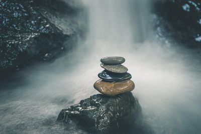 Ein ausbalancierter Steinstapel, vor einen Wasserfall
