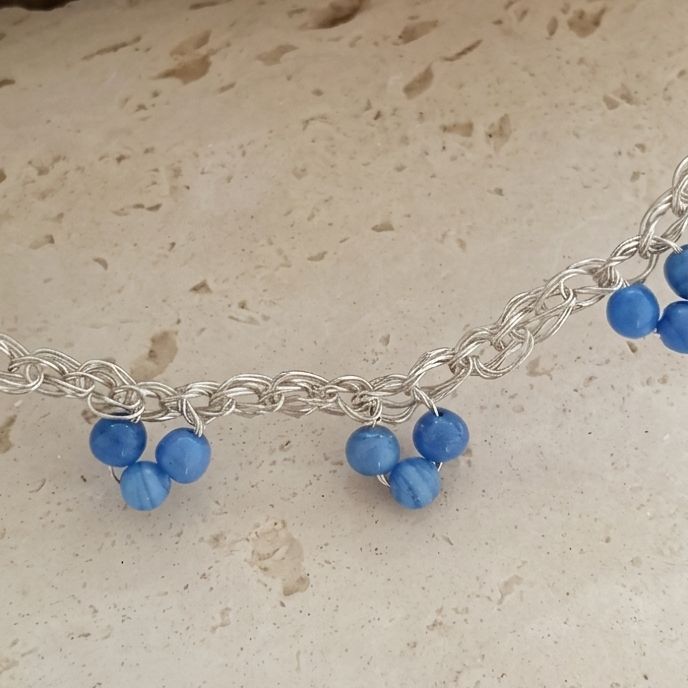 Un girocollo di bacche blu cobalto montate a catena fitta. Il colore è saturo, quasi smaltato.