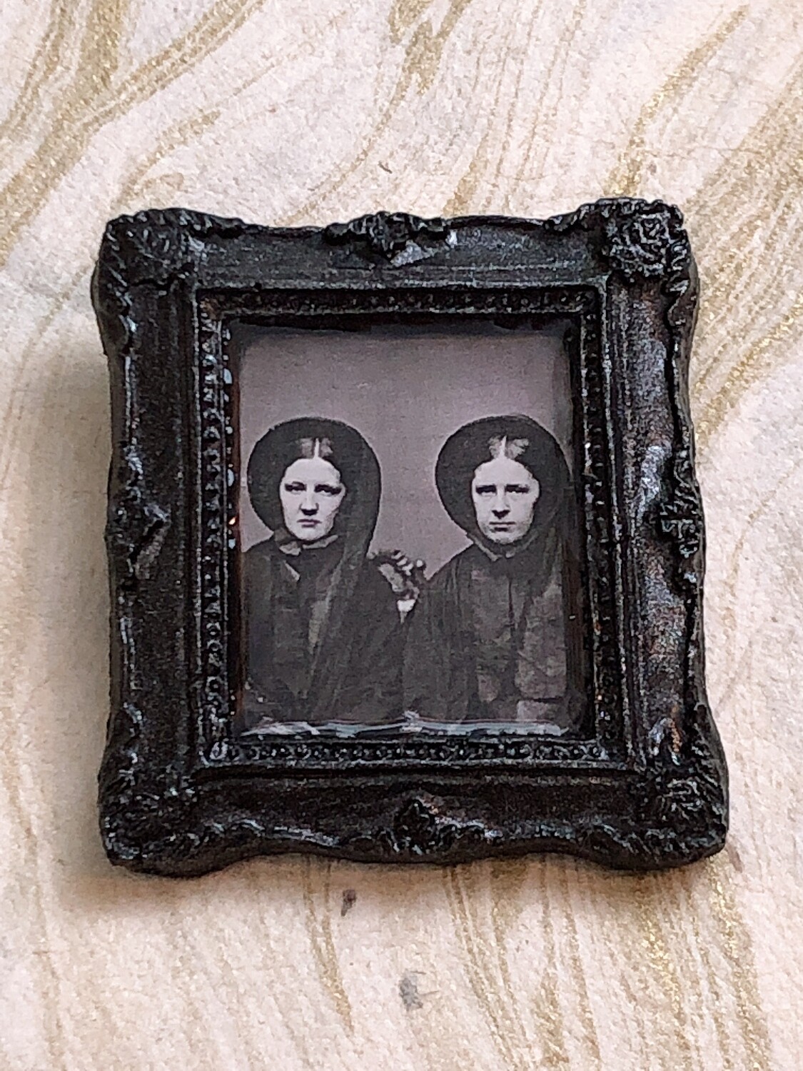 frame brooch (two women)