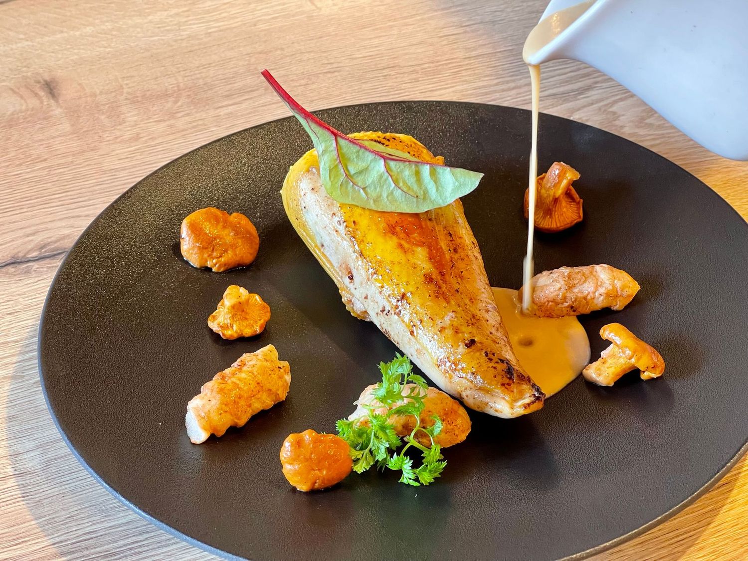 Suprême de volaille aux herbes, crémeux de langoustines, girolles sautées.