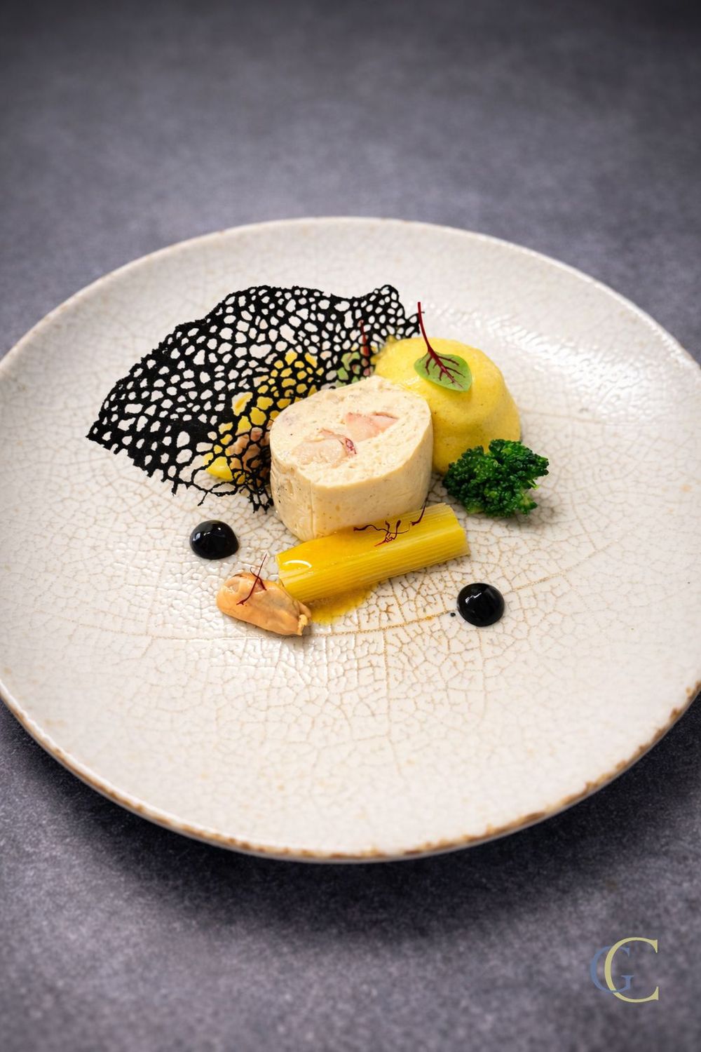 Cervelas de homard, moules et poireau, espuma au safran, tuile perlée à l'encre de seiche