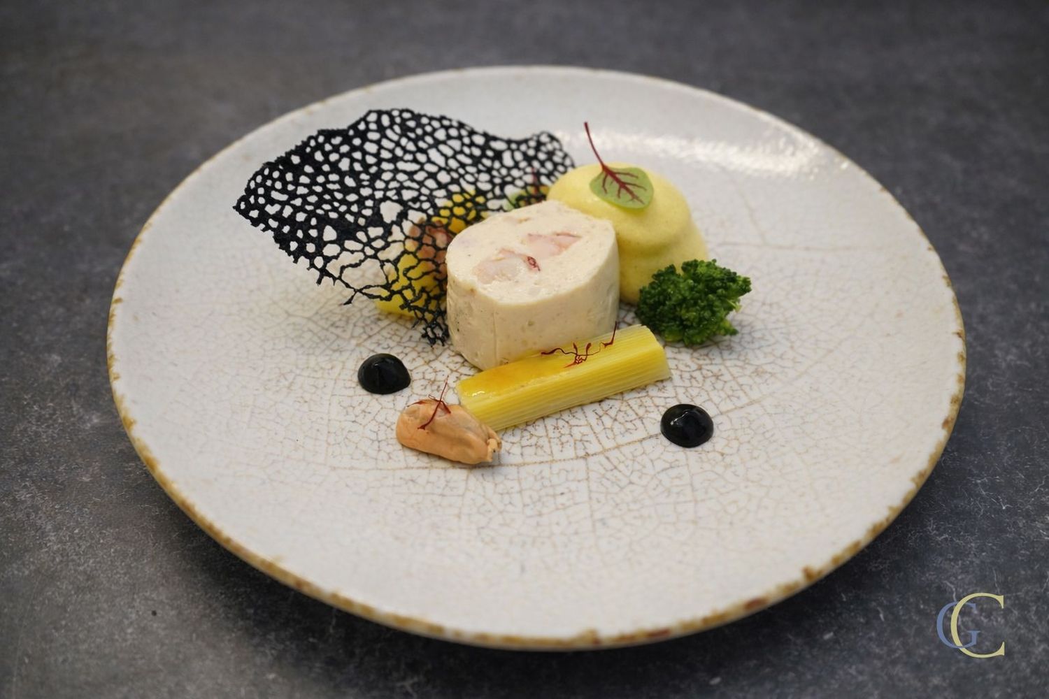 Cervelas de homard, moules et poireau, espuma au safran, tuile perlée à l'encre de seiche