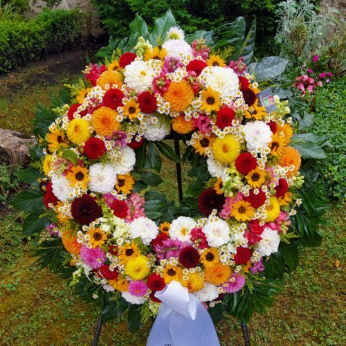 Trauerkranz rundgesteckt mit bunten, saisonalen Blumen Trauerkranz rundgesteckt mit bunten, saisonalen Blumen