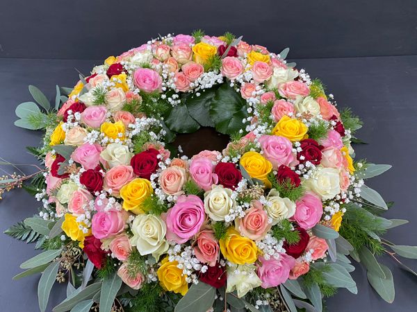 Trauerkranz rundgesteckt mit bunten Rosen Trauerkranz rundgesteckt mit bunten Rosen