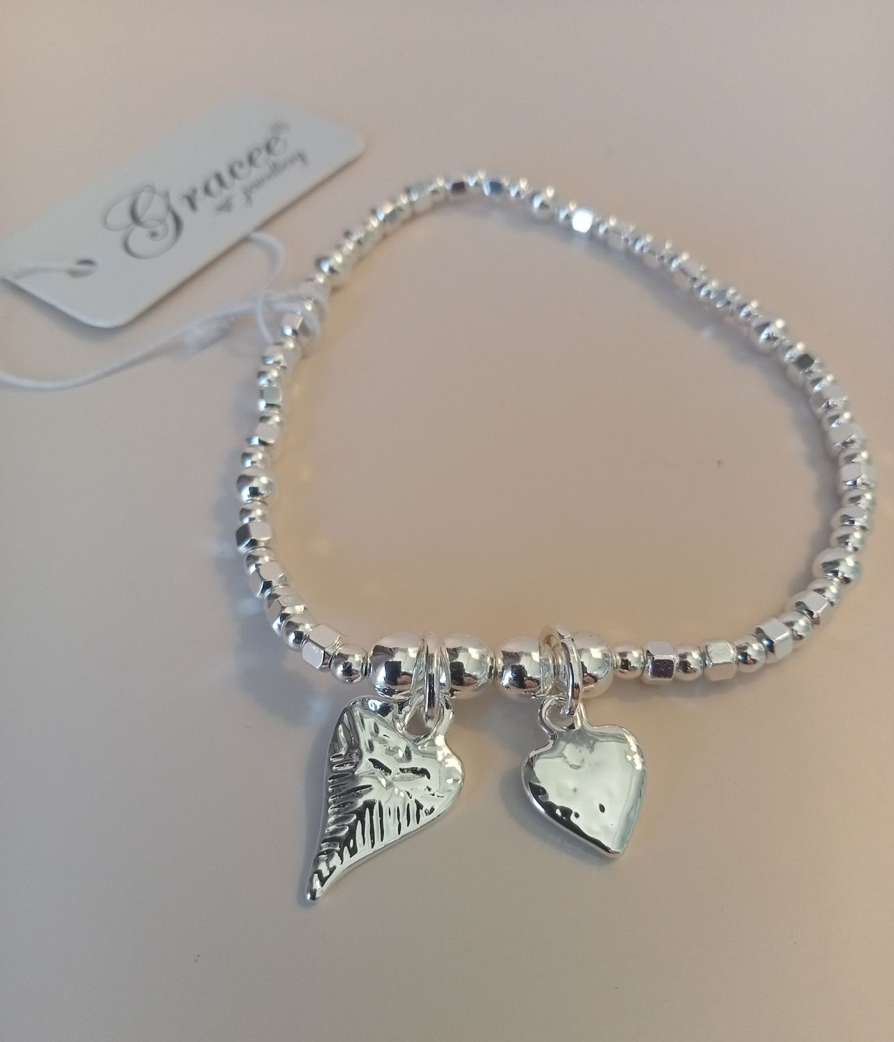 Elasticated bracelet with two heart charms