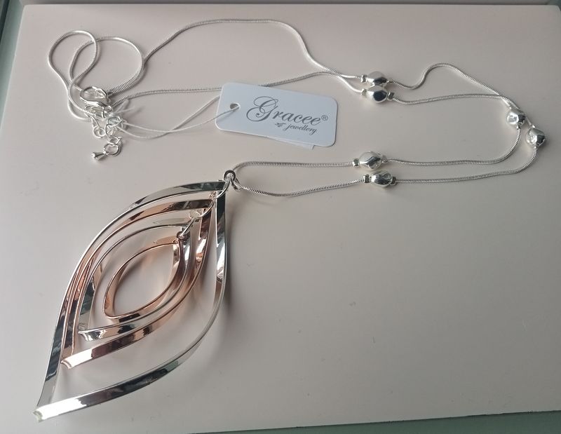 Long silver and gold tone necklace with spiral