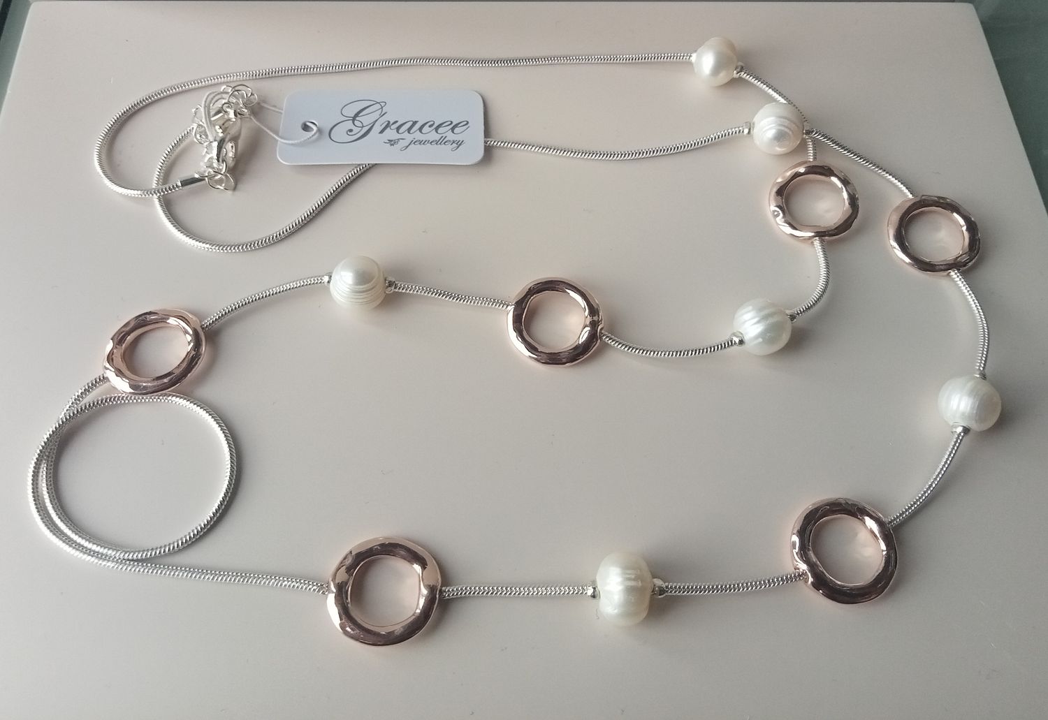 Long silver tone necklace with gold tone circles and pearls