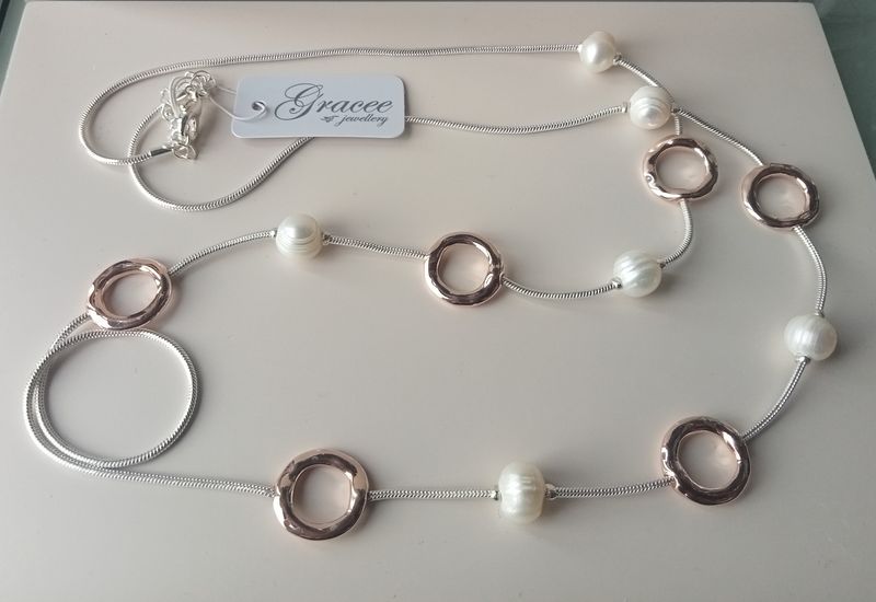 Long silver tone necklace with gold tone circles and pearls