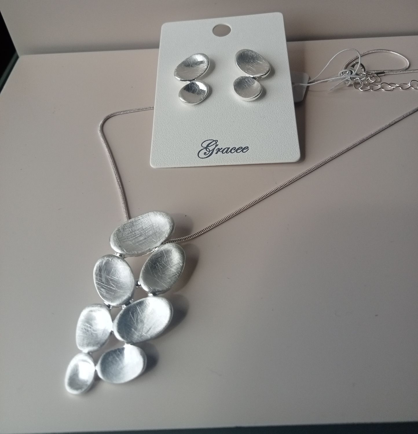 Pebble shaped silver tone pendant