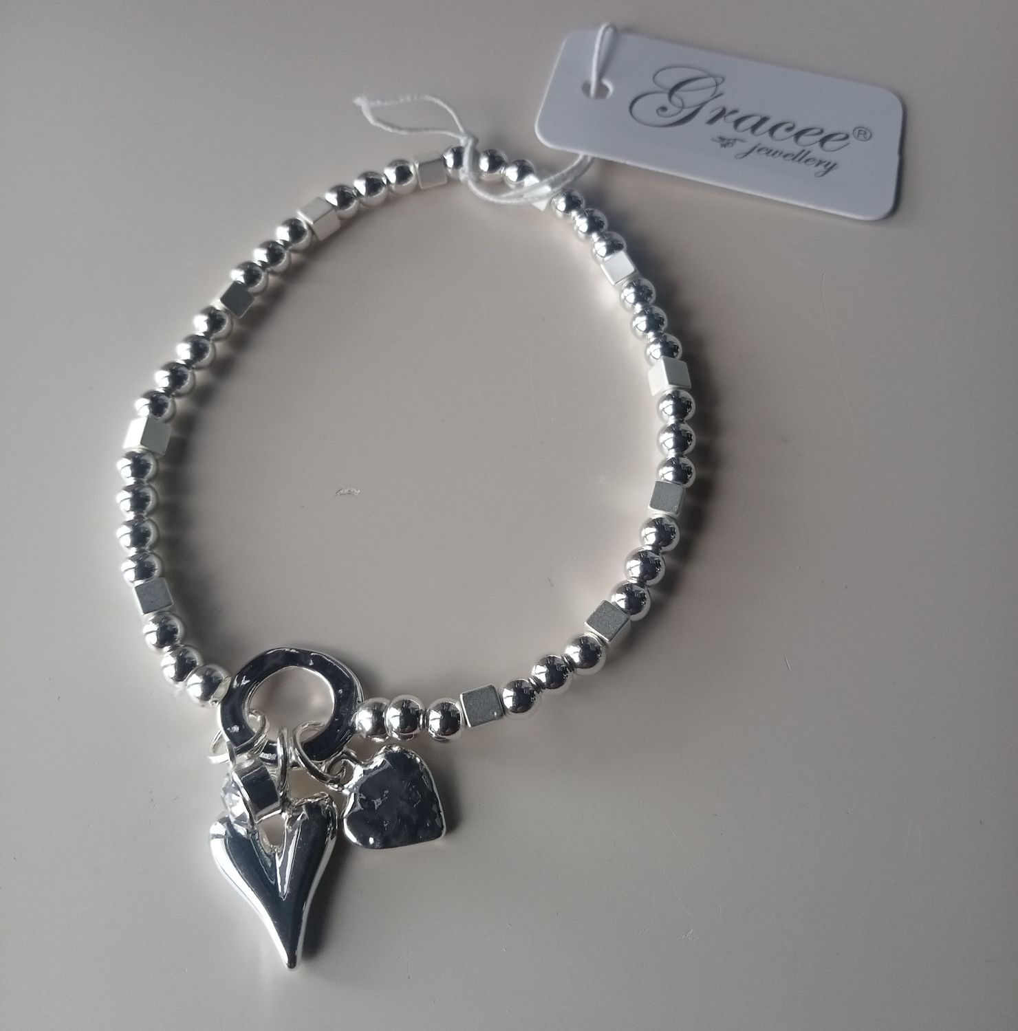 Elasticated bracelet with two hearts and a stone charm