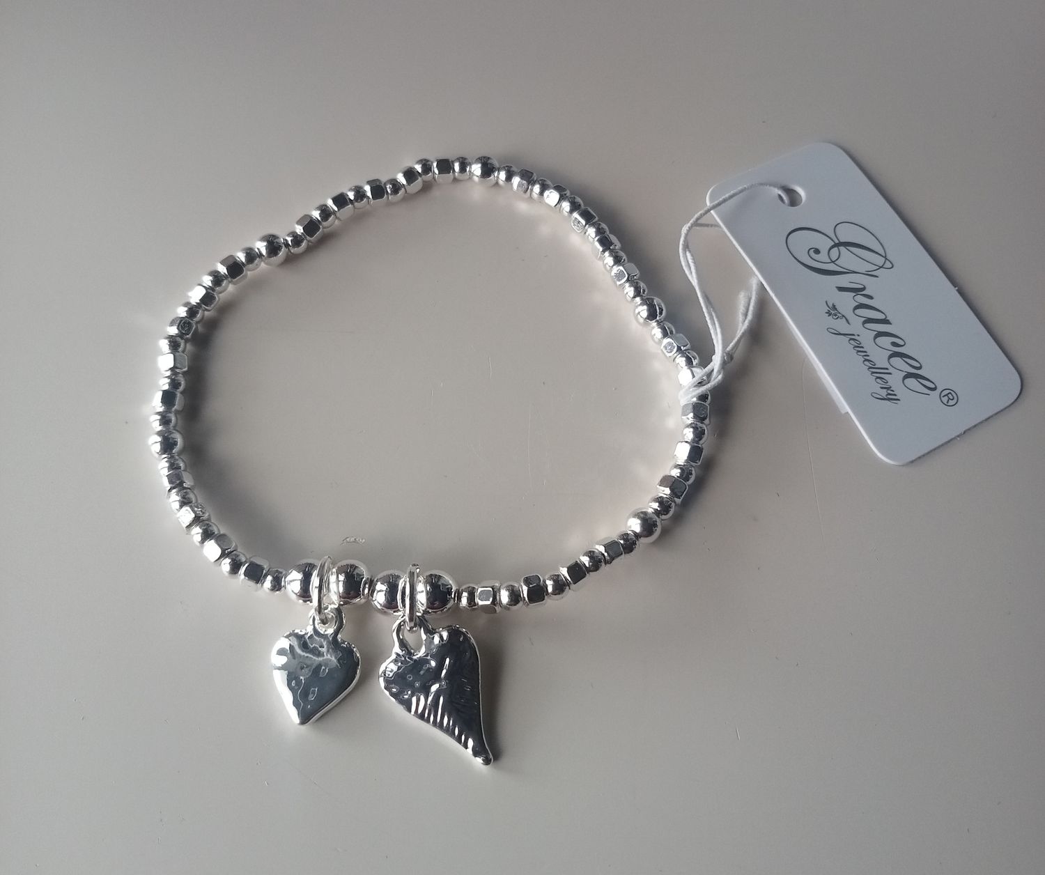 Elasticated bracelet with two heart charms