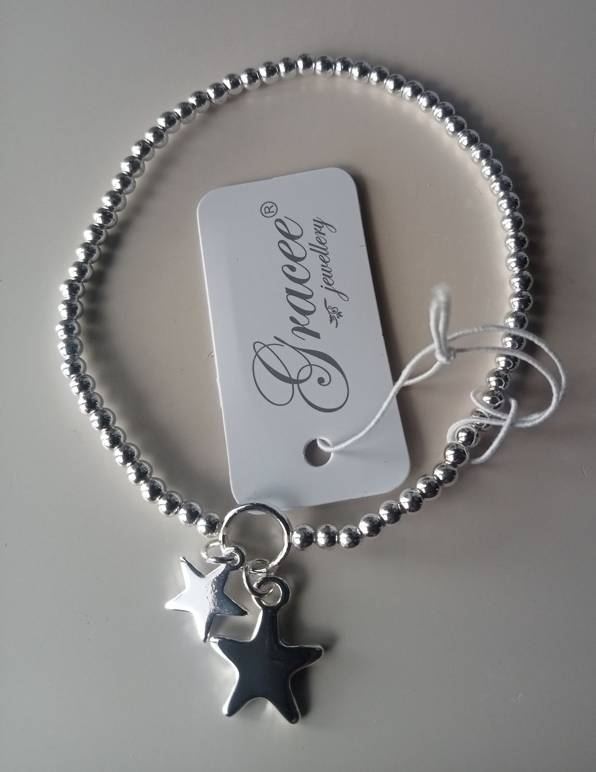 Elasticated bracelet with two star charms
