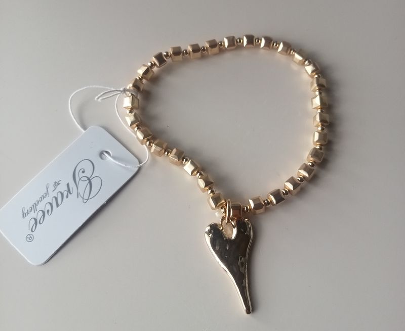 Elasticated bracelet with elongated heart in a gold tone.